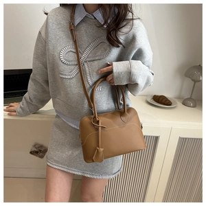 Borsa tote in pelle marrone con cuciture a contrasto e tracolla in un ambiente moderno