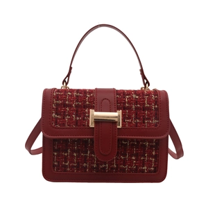 Red tweed handbag with gold thread texture and metallic clasp, front view on white background