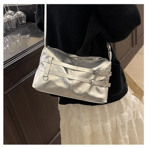 Silver metallic crossbody bag featuring buckle details and pleated texture on model