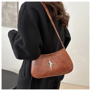 Détail de l'ornement étoile argentée sur le sac à bandoulière en cuir marron vintage