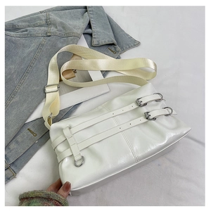 Detail of white matte leather shoulder bag with buckle straps and adjustable strap