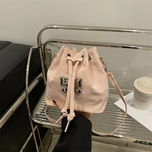 Pink drawstring bucket bag with silver bow accent and crossbody strap for women