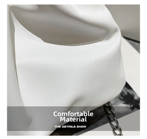 Detailed close-up of white pleated PU leather material and silver chain strap texture