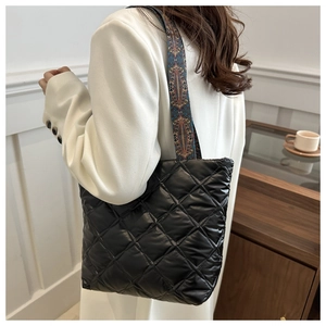 Quilted black tote bag detail with ethnic vintage pattern wide shoulder strap on model