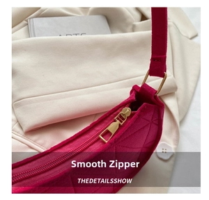 Detailed close-up of smooth golden zipper and quilted felt texture on rose red moon bag