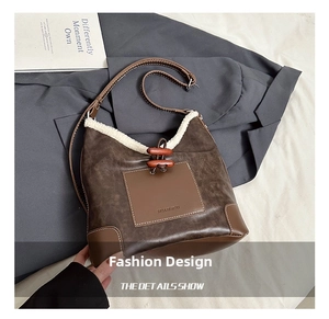 Detail of faux leather bucket bag featuring white fleece trim and wooden toggle closure