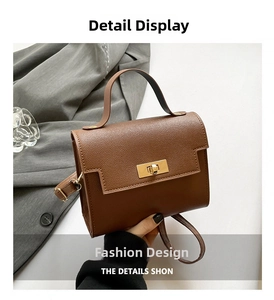 Detail of a brown textured leather crossbody bag with a golden twist lock closure