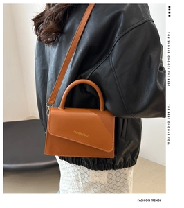 Sac bandoulière en cuir marron avec rabat asymétrique et logo porté par mannequin