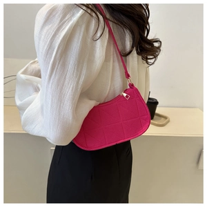 Detail of rose pink felt shoulder bag with triangular quilting and zip closure on model