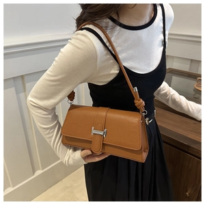 Close-up of brown crocodile texture shoulder bag with silver H clasp and knot detail