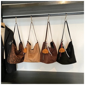 Selection of suede tote bags in leopard, khaki, and brown with cute plush dog charms