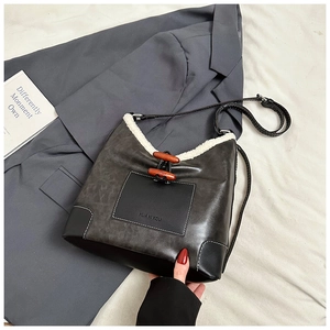 Close-up of vintage grey leather bucket bag with white faux fur trim and wooden toggle closure