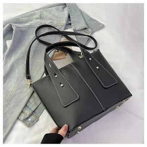 Vue détaillée du sac cabas en cuir noir avec surpiqûres blanches et rivets dorés