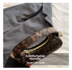 Detailed close-up of leopard print handbag featuring thick handle and gold metal zipper