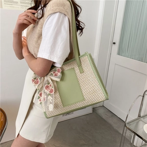 Elegant straw tote bag with light green leather trim and floral silk scarf detail
