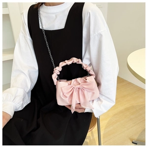 Detail of pink bow handbag with pleated cloud handle and silver chain strap