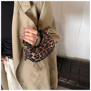 Detail of leopard print crescent bag with metal zipper and adjustable handle
