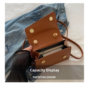 Détail montrant la capacité intérieure du sac carré en similicuir marron avec fermoir