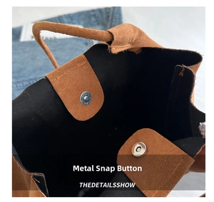 Detail of silver magnetic snaps on brown suede tote bag with black lining