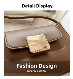Detail view of smooth brown leather shoulder bag featuring a large gold metallic buckle