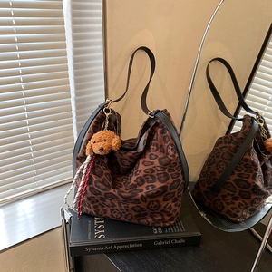 Large leopard print hobo tote bag with black leather strap and a cute puppy charm
