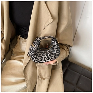 Detail of leopard print crescent bag with premium gold hardware and textile texture