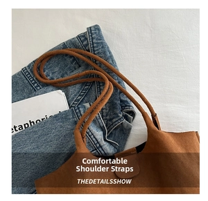 Detail of slim double shoulder straps on a brown frosted suede bucket tote bag