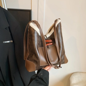 Brown leather bucket bag with white faux fur trim and toggle closure shown by model