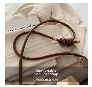 Detail of a brown leather shoulder bag featuring a unique knotted strap and gold hardware