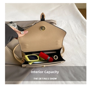Internal capacity of beige crossbody bag showing phone, sunglasses and lipstick
