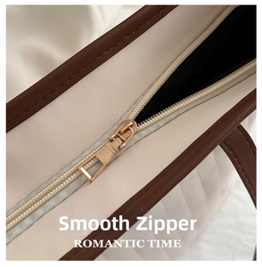 Detail of smooth gold zipper and pebble leather texture on this stylish tote bag