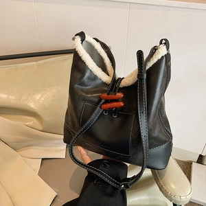Winter black leather bucket bag with white faux fur trim and toggle buttons detail