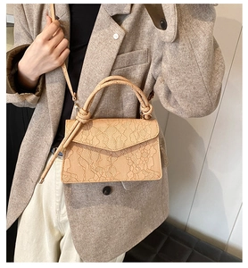 Detail of apricot lace handbag with twisted knot handle and matching shoulder strap