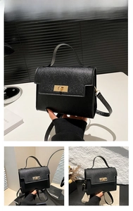 Detail of black cross-pattern leather handbag with gold twist lock and handle