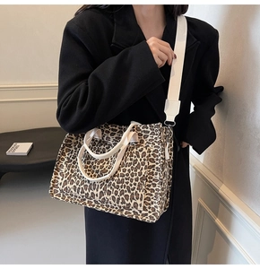 Close-up of leopard print canvas tote bag featuring dual handles and wide shoulder strap