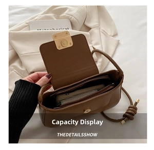Detail showing high-capacity interior of dark brown leather bag with golden magnetic clasp