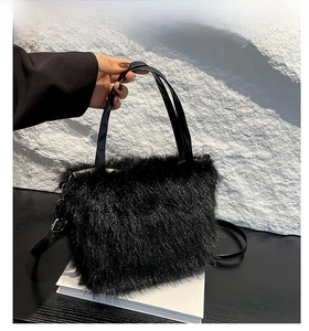 Detail of black faux fur shoulder bag with leather handles and adjustable strap