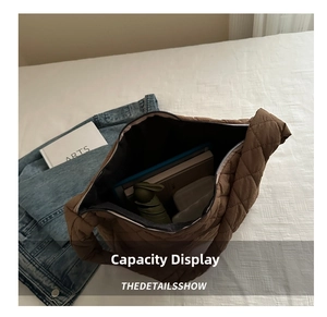 Spacious interior of brown quilted tote bag showing green umbrella and notebook