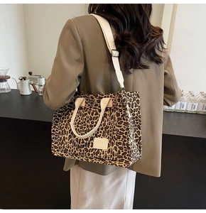 Detail of leopard print tote bag with white branded label and adjustable shoulder strap