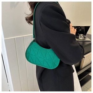 Close-up of green felt shoulder bag with triangular quilting shown on a model