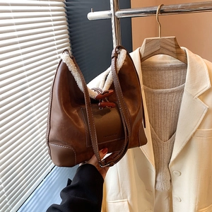Brown leather bucket bag with white faux fur trim and wooden toggle closure for autumn