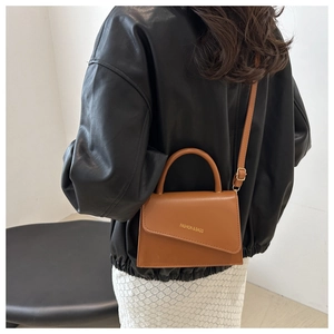 Vue arrière d'un mannequin portant un petit sac bandoulière marron minimaliste chic