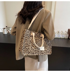 Detailed leopard print canvas tote bag with JINGPIN label worn by model in a cafe