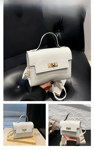 Detail of white cross-grain leather handbag featuring a gold twist lock and shoulder strap