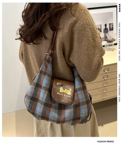 Dettaglio della borsa hobo a quadri con patta in pelle marrone e simpatico cane giallo