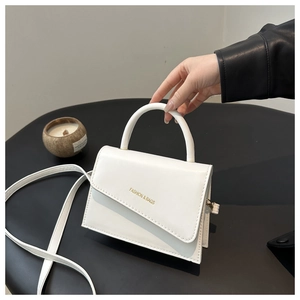 Détail du mini sac blanc avec rabat diagonal unique et lettrage de mode doré chic