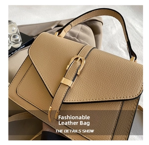 Detail showing beige lizard-embossed faux leather texture and gold buckle closure