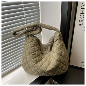 Close-up of quilted diamond pattern and soft nylon texture on the green shoulder bag