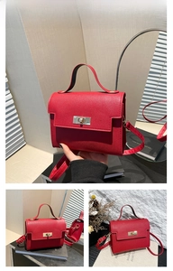 Detail view of red textured leather handbag with gold metal clasp and top handle
