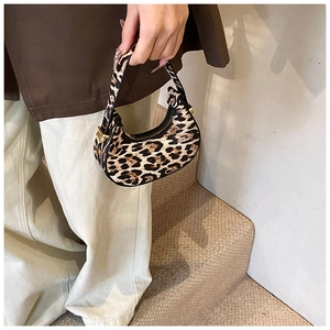 Detail of leopard print crescent bag with gold zipper and smooth PU leather texture